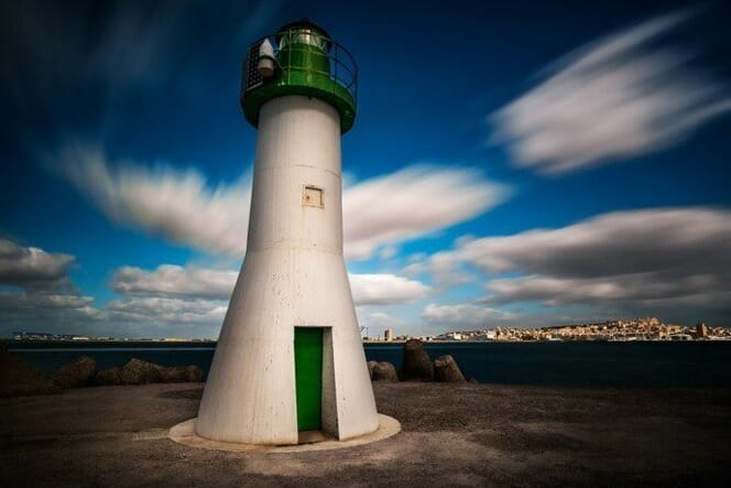 lighthouse green white blue sky clouds blur slow shutter speed