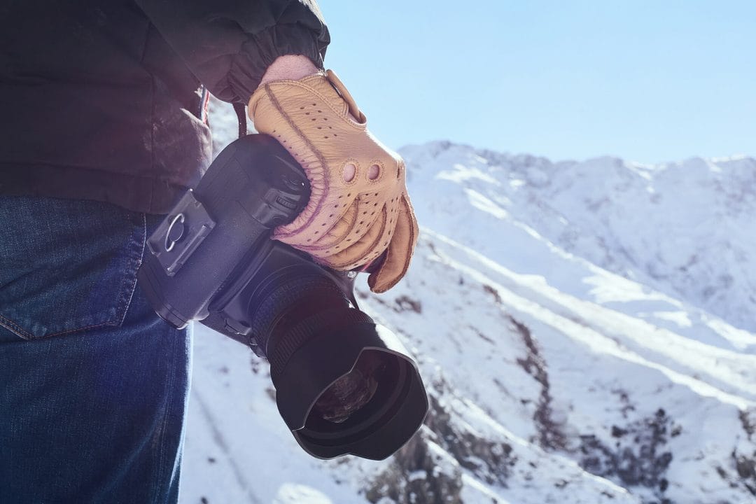 photographer camera dslr mountain snow glove blue sky