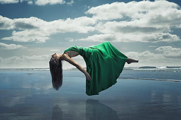 model photography floating over water in green dress