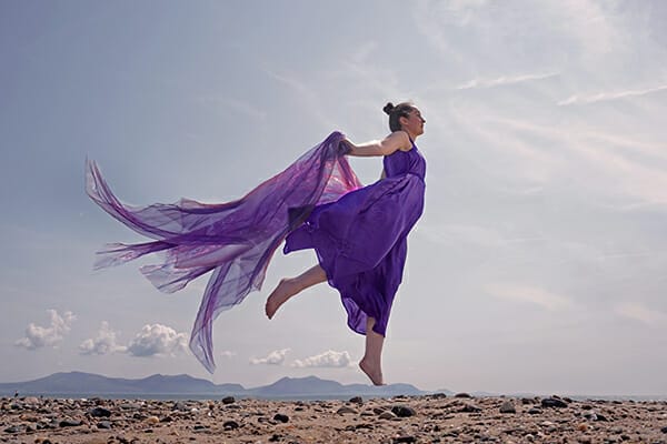 model floating purple dress beach