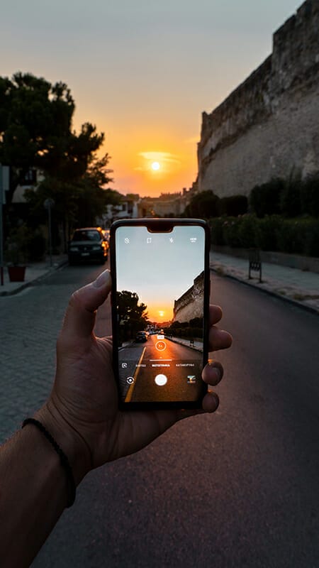 smartphone taking picture of sunset