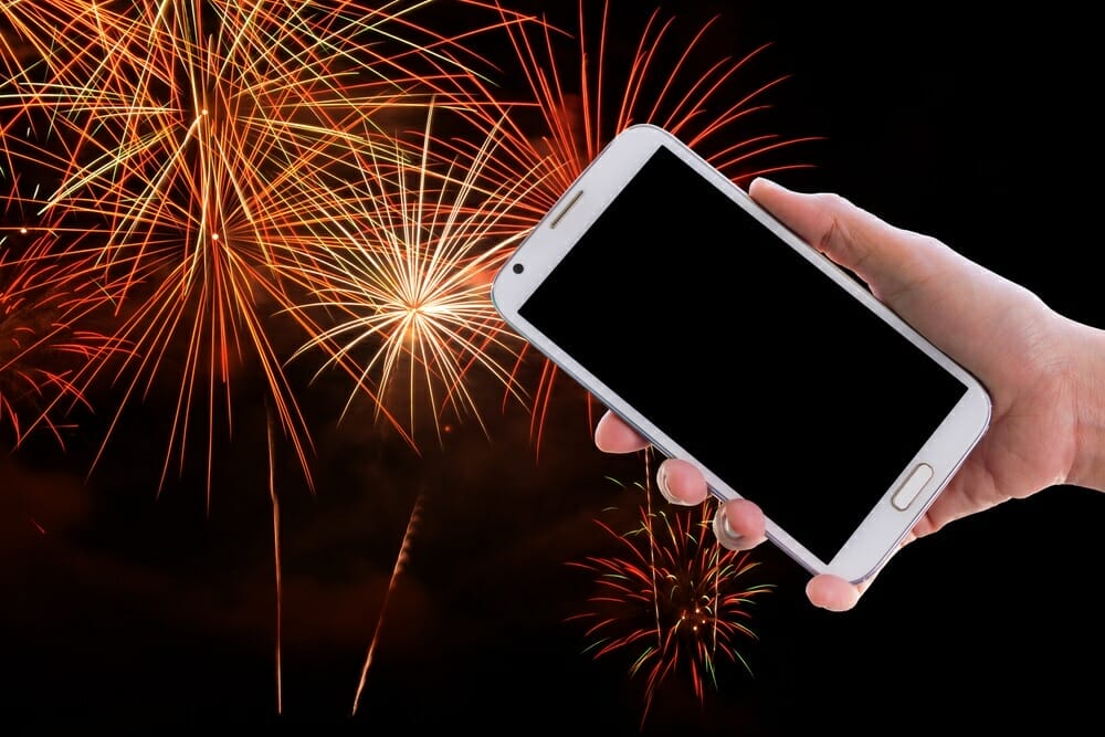smartphone being held in front of fireworks