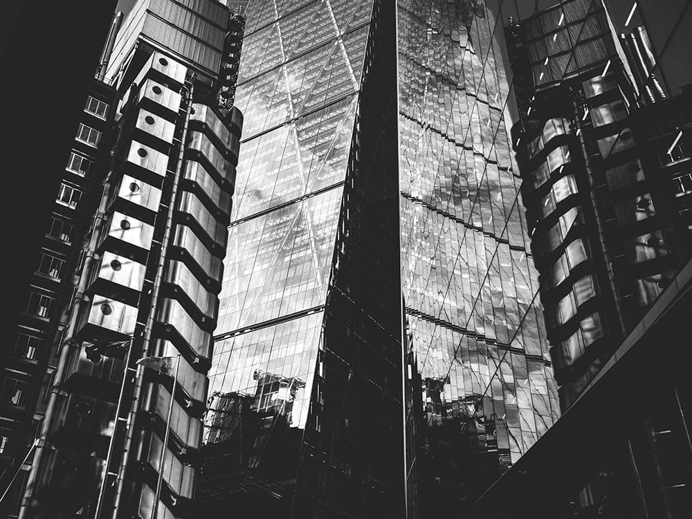 black and white photo of skyscrapers with reflections
