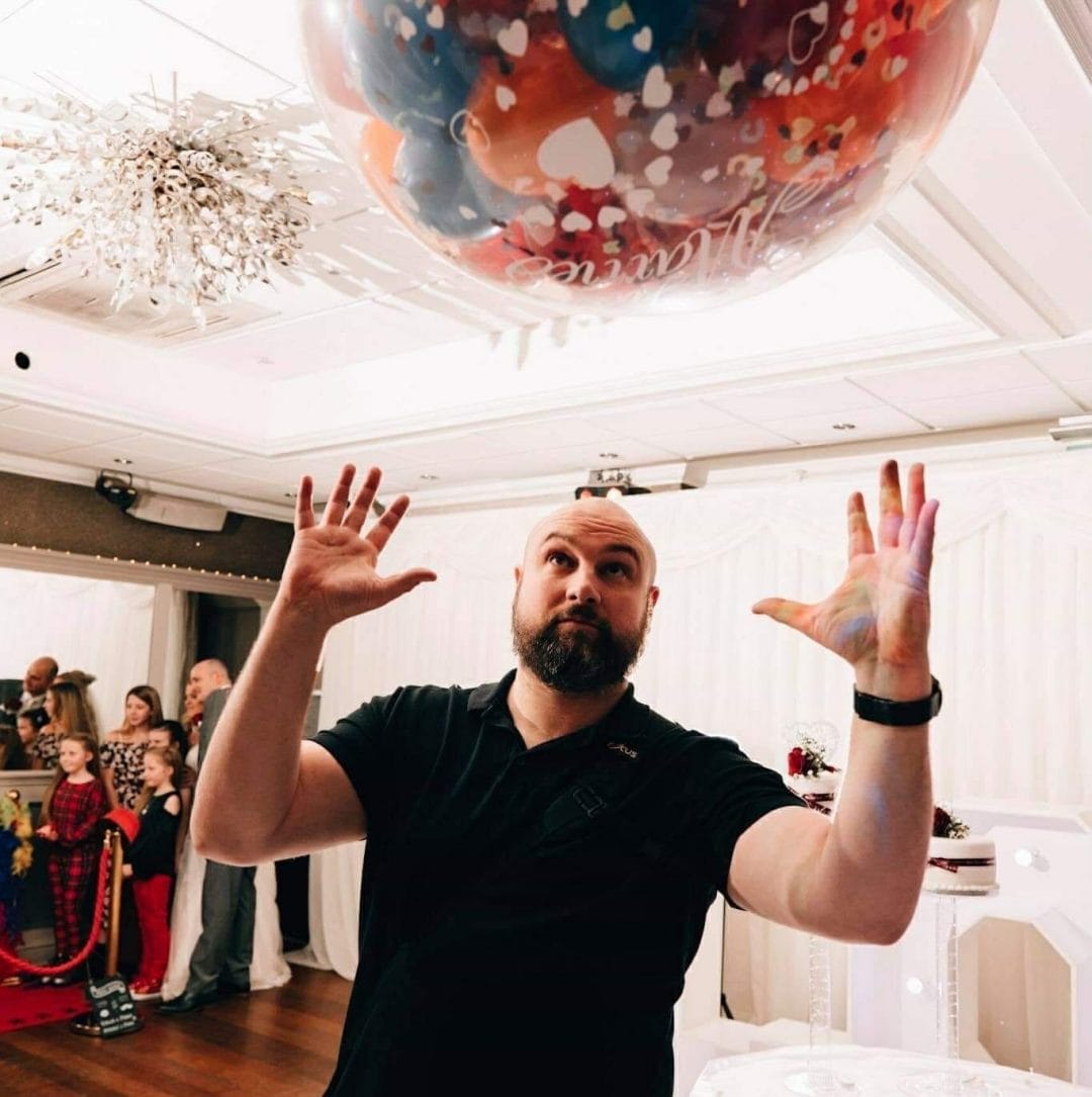 a wedding photographer trying to catch a balloon