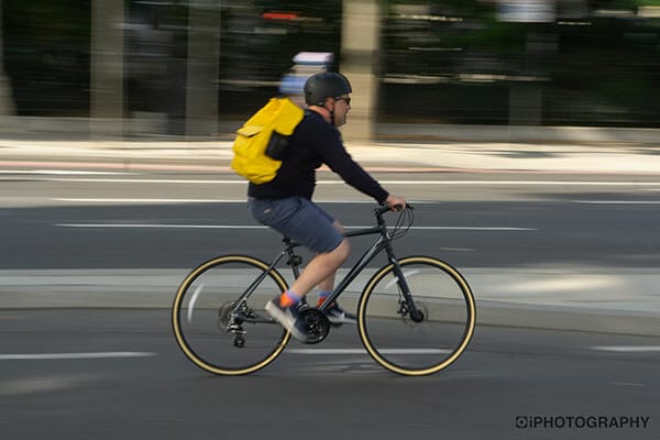 Why Are My Pictures Blurry cyclist blurred with a yellow bag