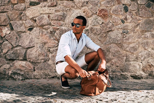 posing men blog image man wearing sunglasses looking in a bag crouched down