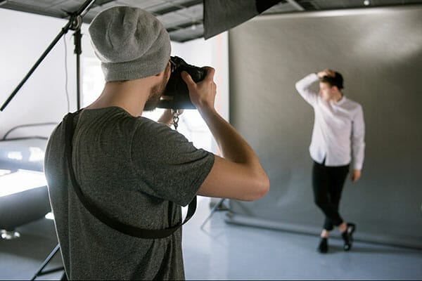 Unrecognizable,Casual,Photographer,Taking,Shots,Of,Male,Model,In,Studio. working with models Unrecognizable casual photographer taking shots of male model in studio. Fashion photoshoot backstage