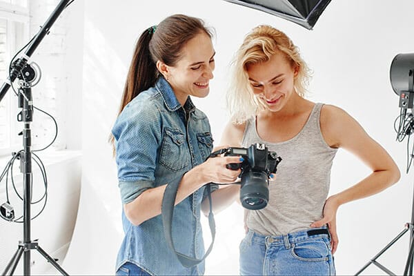 Girl photographer shows the picture of the model working with models