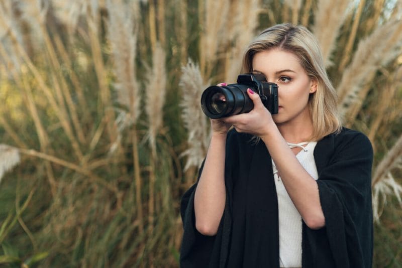 Female Photographer using a zoom lens to take a photograph