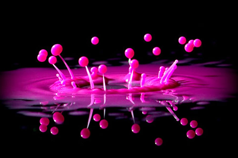 splash of pink paint on a black surface
