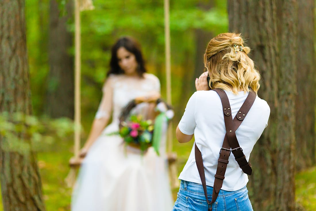 a wedding photographer taking a photo of a bride and groom