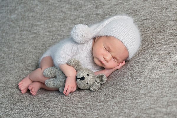 Newborn boy sleeping in funny bonnet