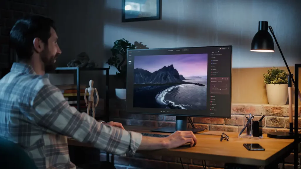 man sat a computer editing a landscape photo on luminar neo