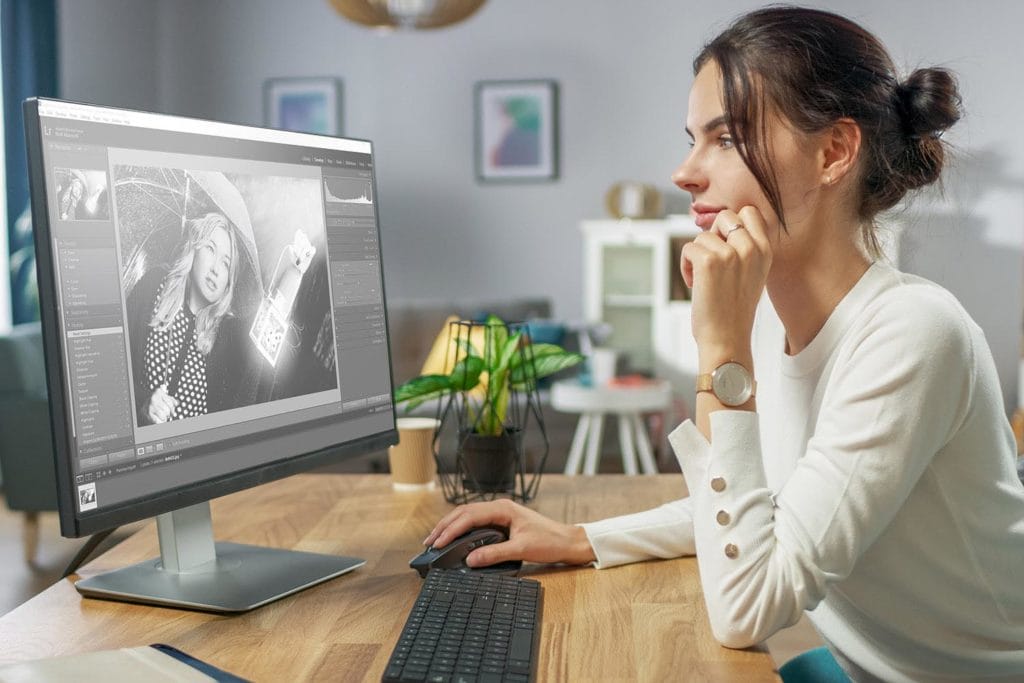 a woman sat at a computer editing a photo in Lightroom