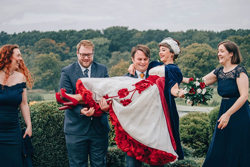 bride being held up by two men at a wedding