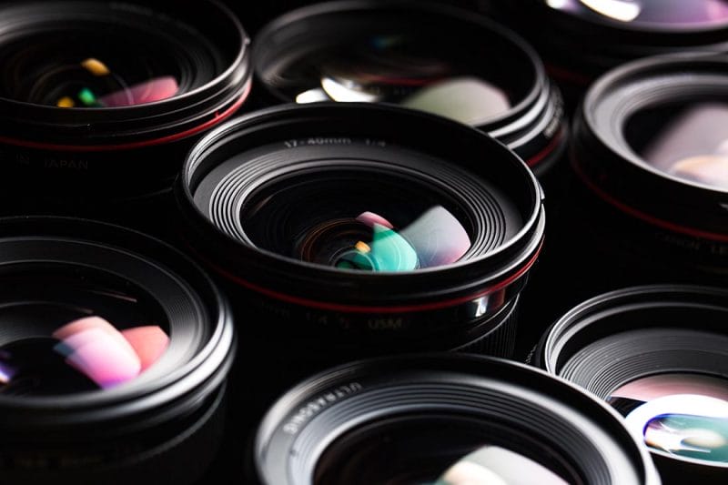 Modern camera lenses with reflections, low key image