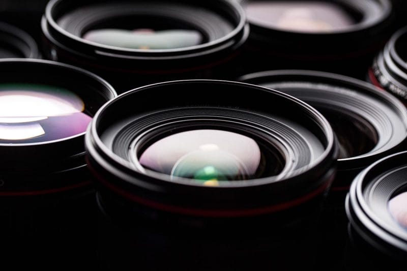 Modern camera lenses with reflections, low key image