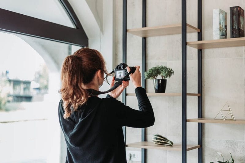 Female photographer photographing products in the office with dslr camera