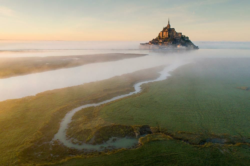 aerial view from drone to old castle in foggy morning in France