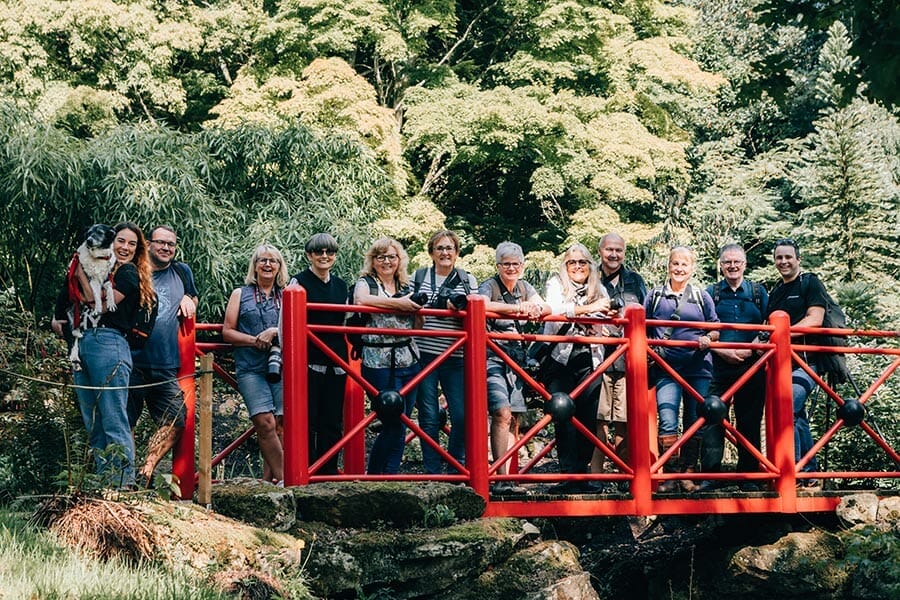 a group of photographers stood on a wooden bridge at Batsford Arboretum