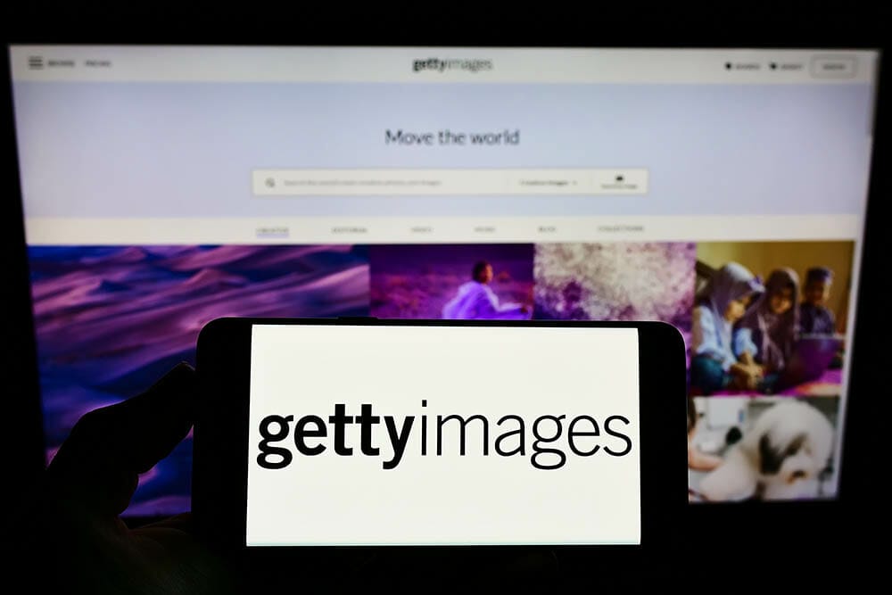 Stuttgart, Germany - 12-12-2021: Person holding smartphone with logo of stock photo provider Getty Images Inc. on screen in front of website. Focus on phone display. Unmodified photo.