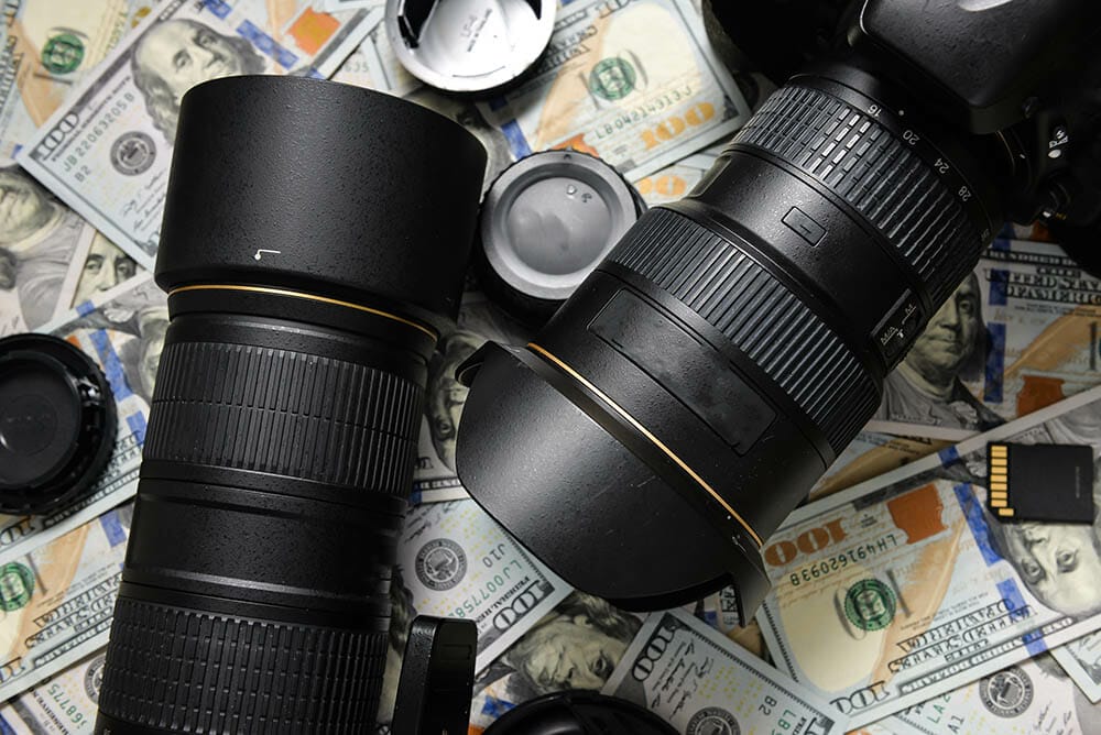 Background American one hundred dollar bills and DSLR camera devices. Making a lot of money by DSLR camera, Success business concept.