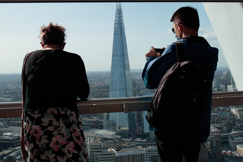 A man talking a photo from the Walkie Talkie Building in London looking at the Shard