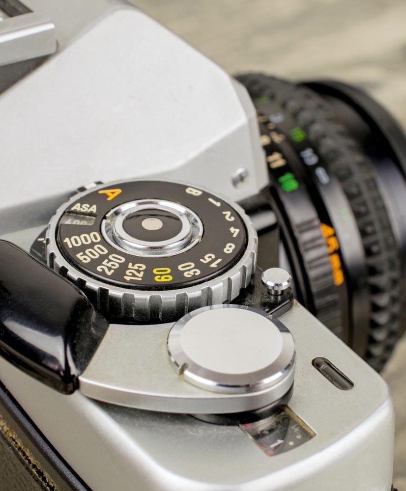 A close up of a asa iso dial on a vintage 35mm film analog camera