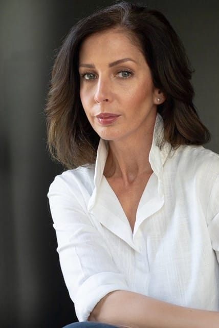 Portrait of a lady with dark hair wearing a white shirt