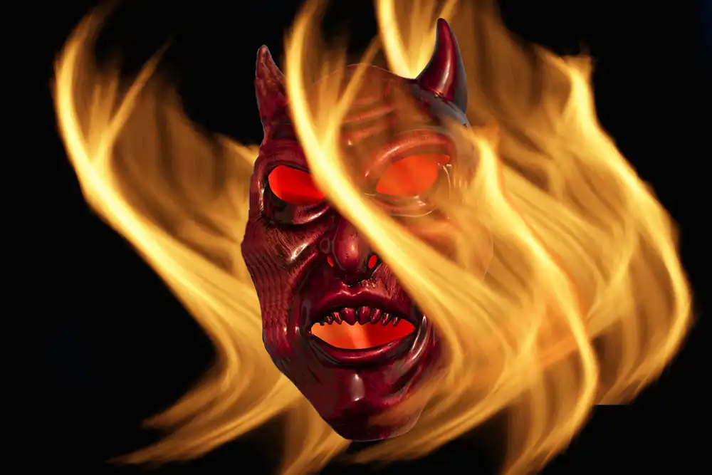 A devil mask surrounded by flames on a black background. Copyright Bev Trainer (iPhotography Student)