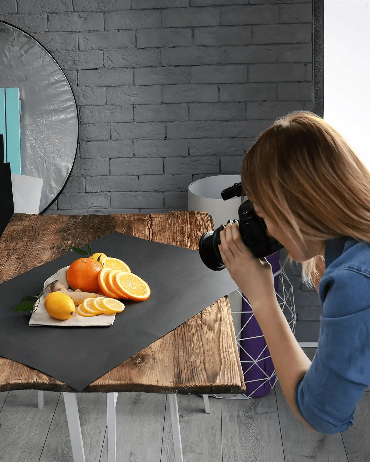 female photographer taking photos of fruit in a home studio
