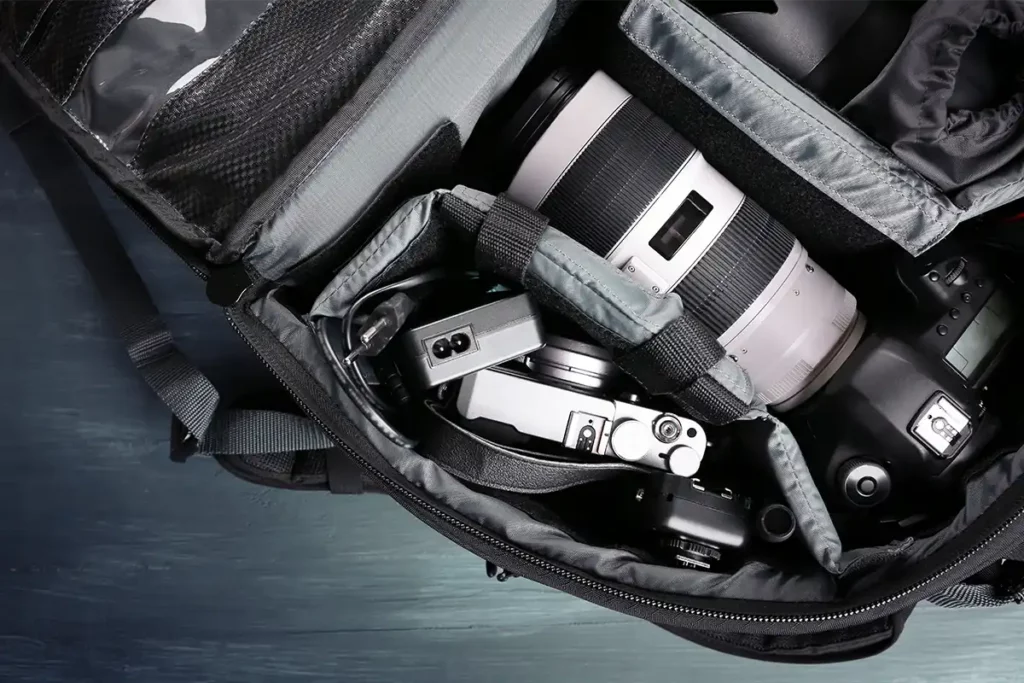 A camera bag containing a digital camera and a lens