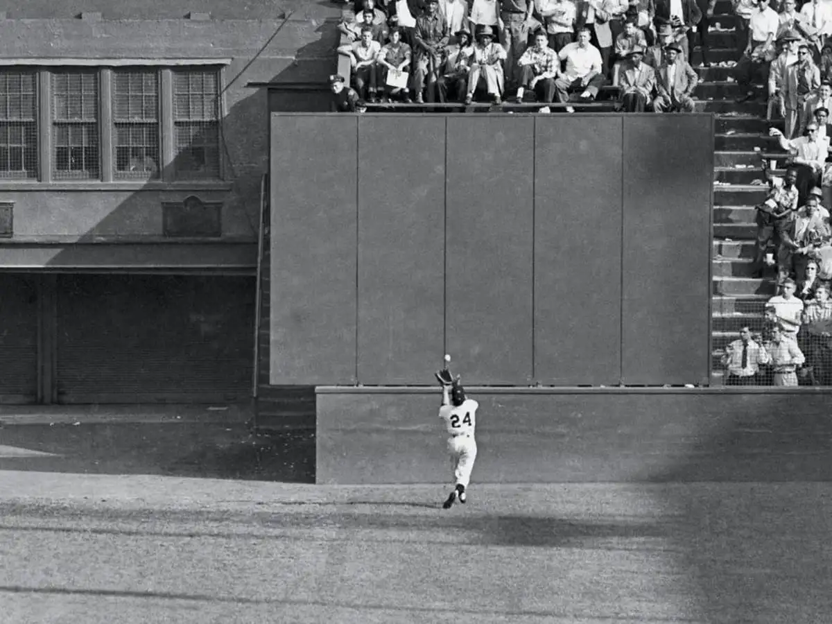 Black and white photo of baseball player wearing number 24 catching a ball in 1954