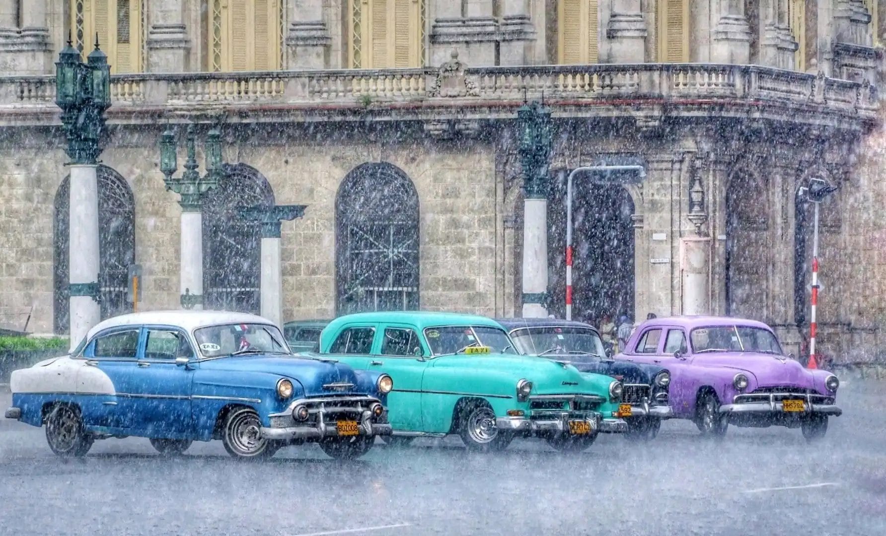 three retro cars in the rain